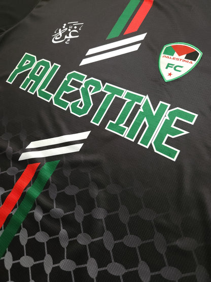 Close-up of Black Palestine football jersey showing Palestinia FC crest, red and green stripes, and keffiyeh-pattern fabric