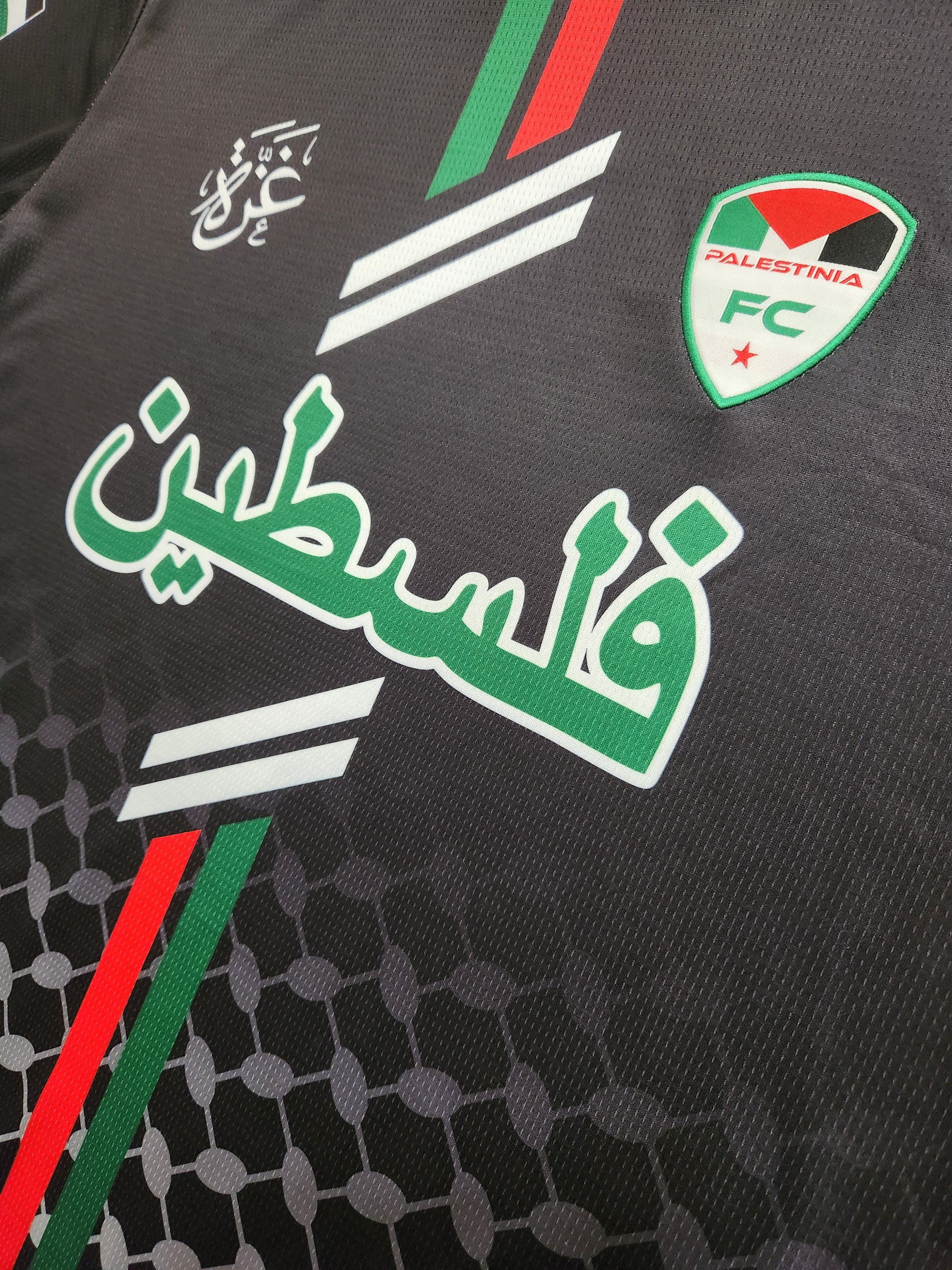 Close-up of Palestinia FC Black Arabic Jersey showing Arabic Palestine text, embroidered crest, and red-green flag stripes