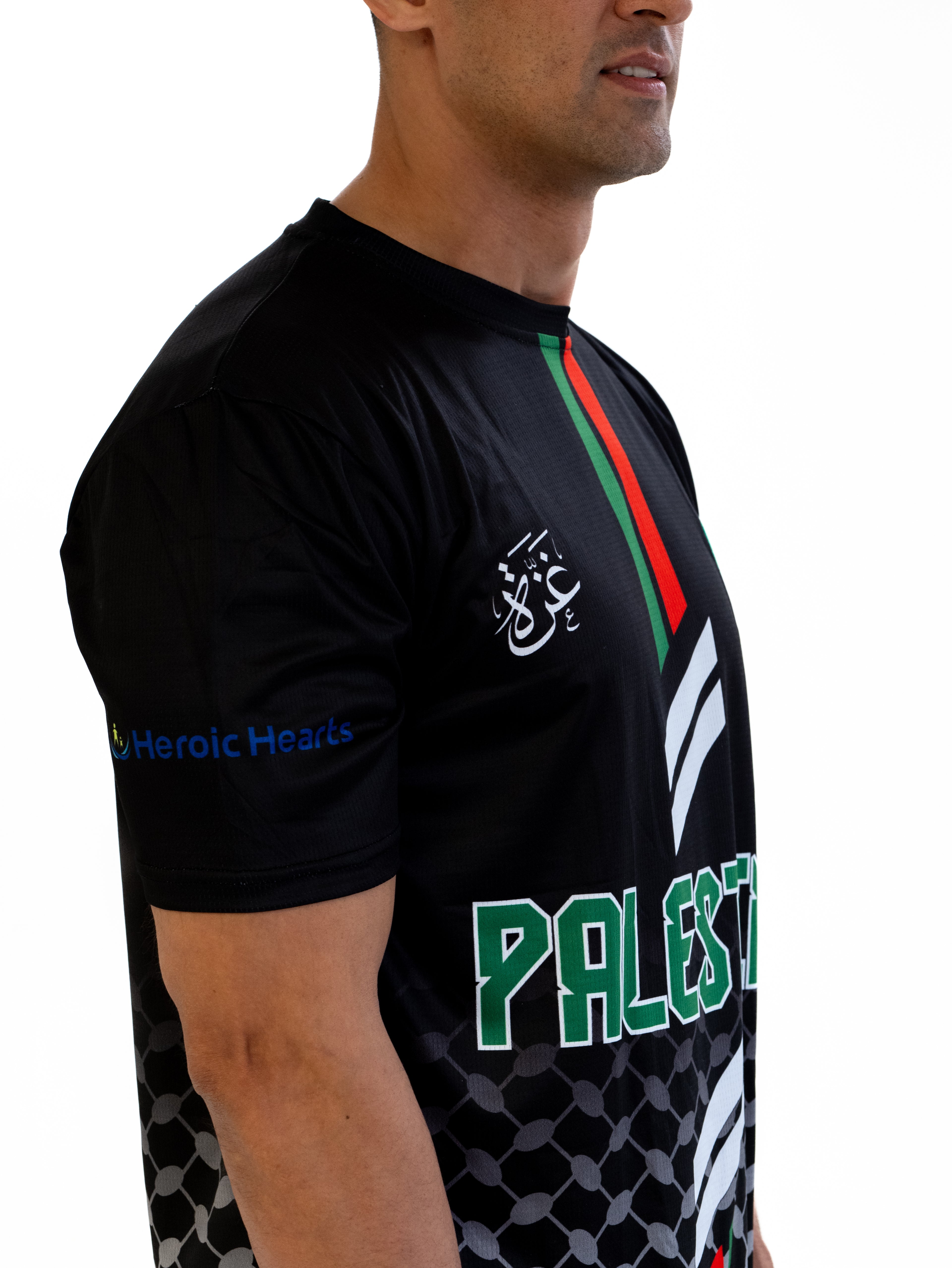 Model wearing Black Palestine football jersey with red and green vertical stripes and keffiyeh pattern