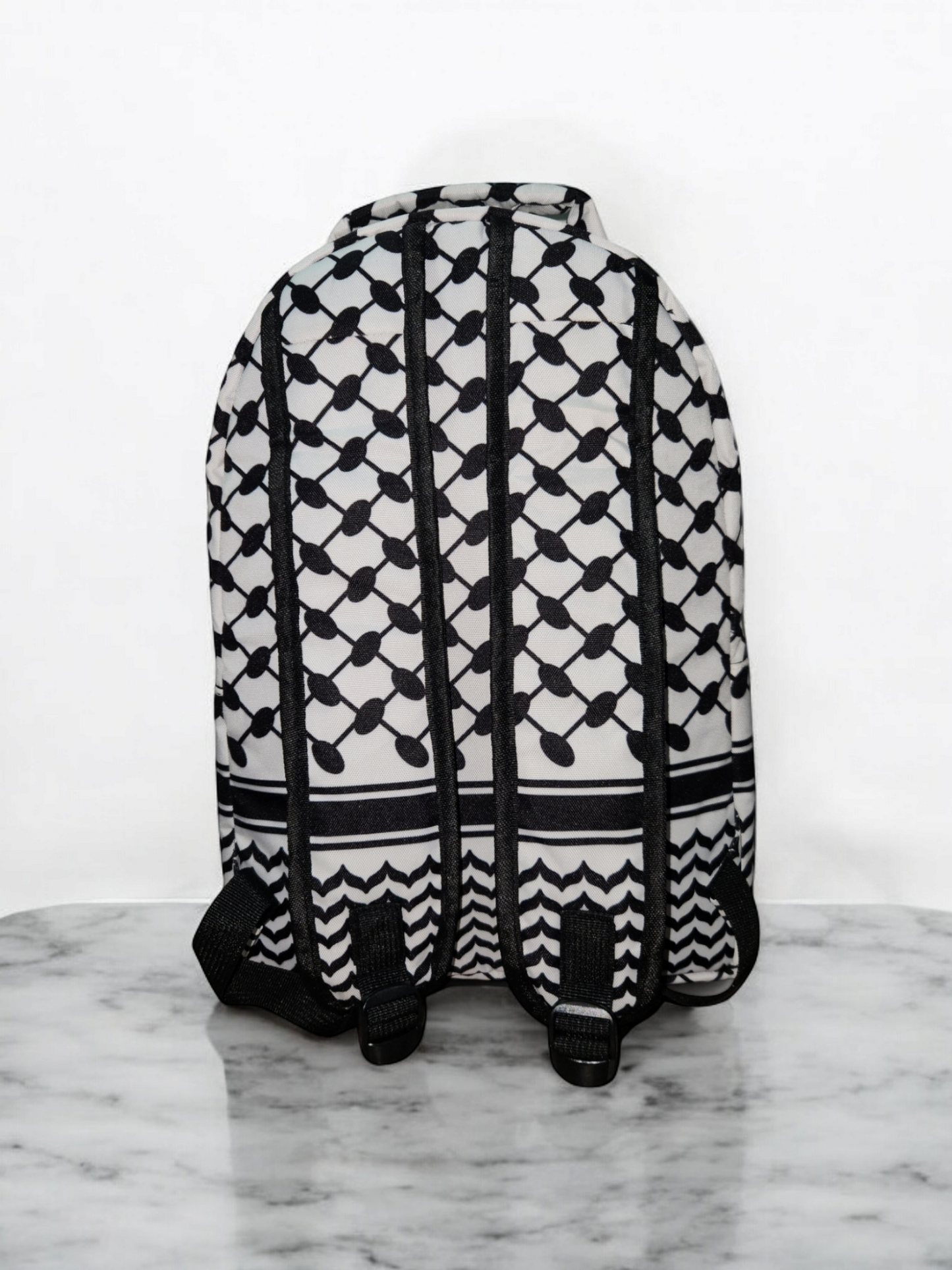 Back view of Palestinia FC Keffiyeh Backpack showing kufiya pattern and adjustable black straps on marble background