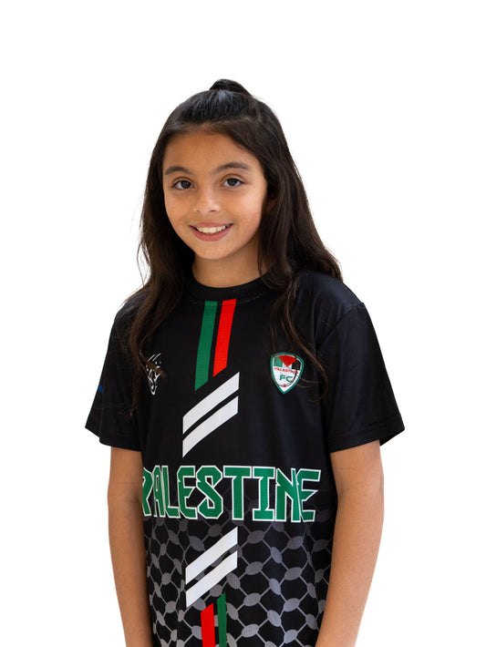 Girl wearing Kids Black Palestine football jersey with red and green stripes, keffiyeh pattern, and Palestinia FC crest