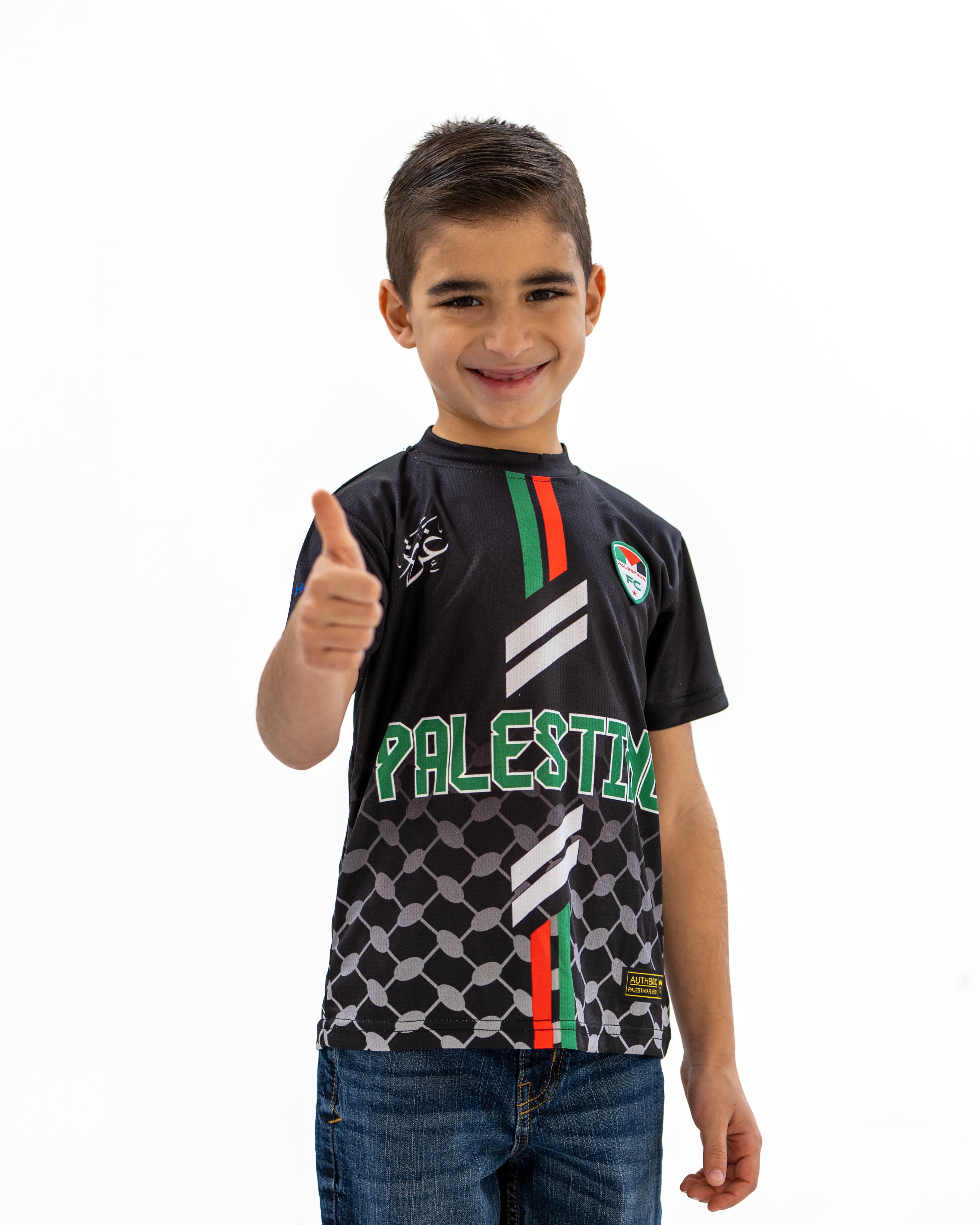 A child wearing a short-sleeved black jersey with red and green stripes and the text 'PALESTINA' on the front.