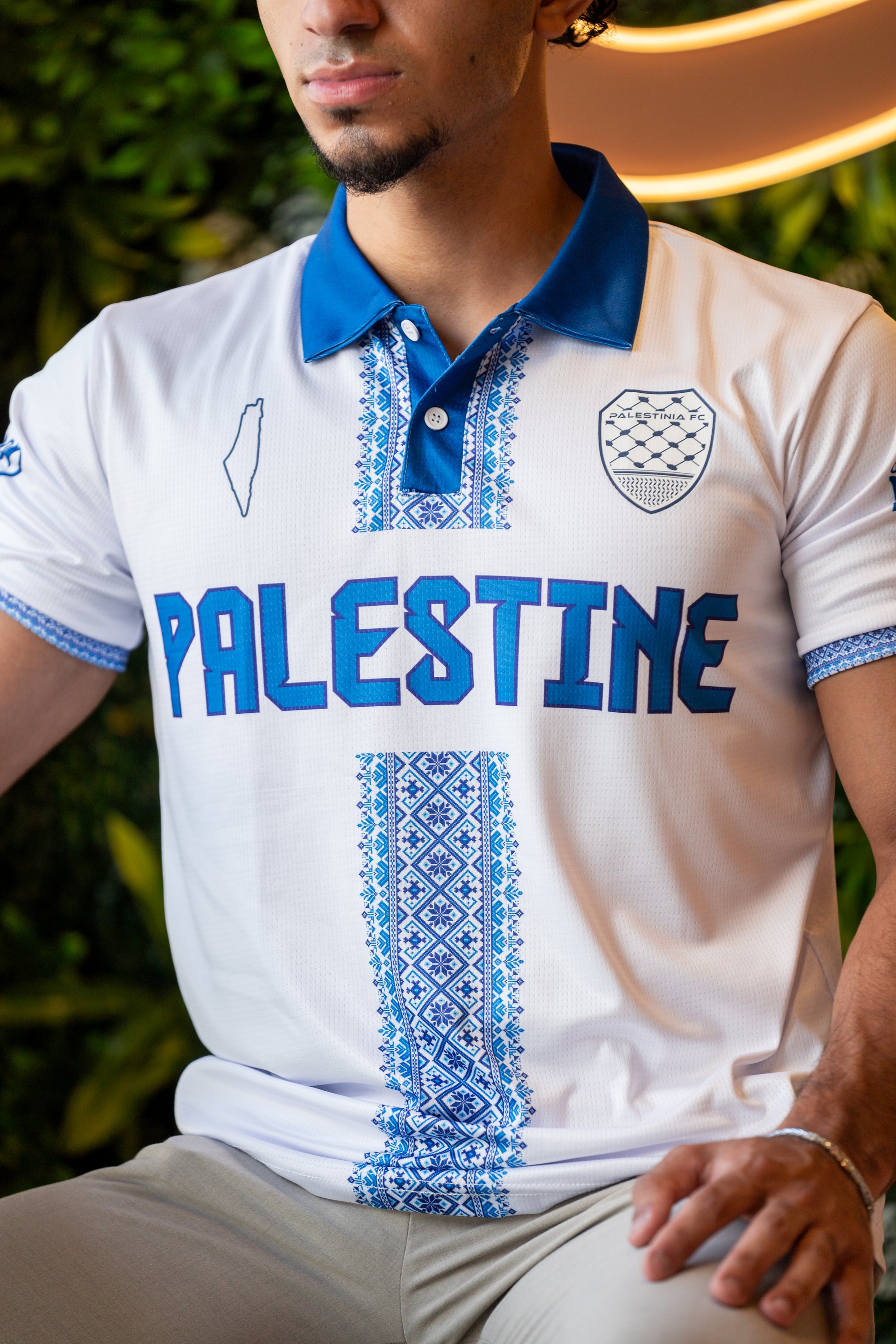 Model wearing white and blue Palestine Tatreez jersey representing cultural pride