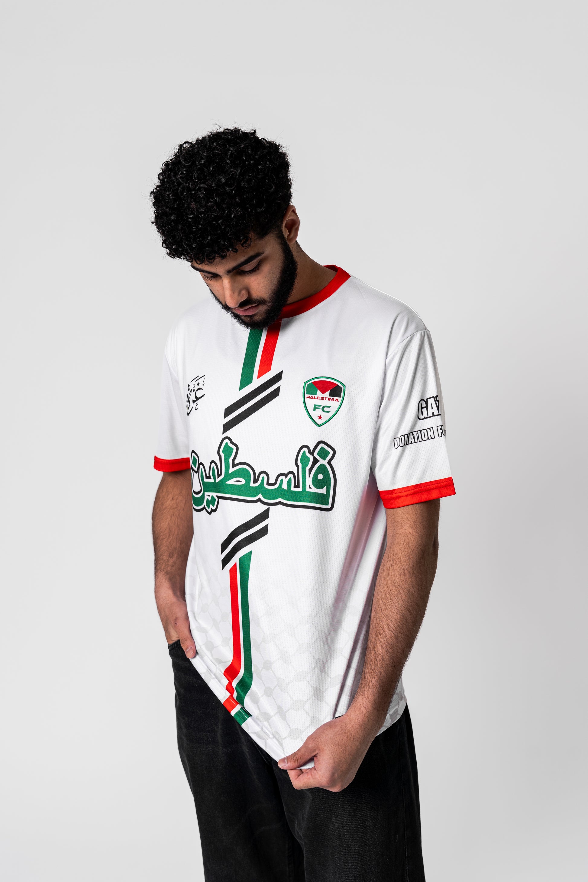 Model wearing Palestinia FC White Arabic Jersey with Arabic Palestine text, red-green stripes, and embroidered crest