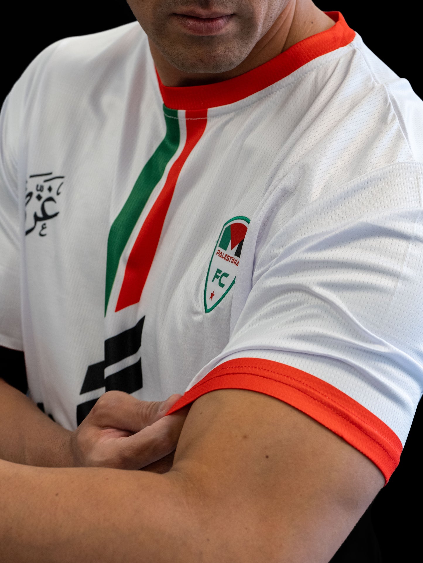 Model wearing White Palestine football jersey with red and green vertical stripes and Palestinia FC crest